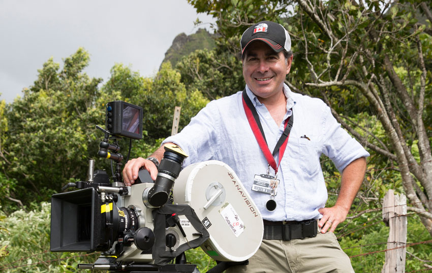 John Swartzman standing next to a Panavision Panaflex film camera.